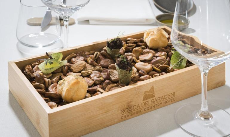 Elegante scatola di legno con prelibatezze su letto di legumi.