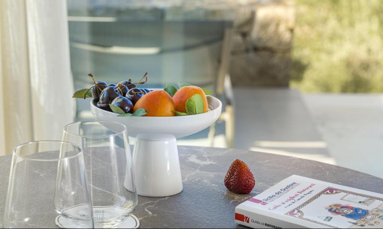 Frutta fresca su tavolo elegante, vista panoramica e libro intrigante.