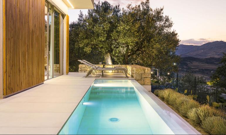 Piscina elegante con vista su colline al tramonto, atmosfera rilassante e naturale.