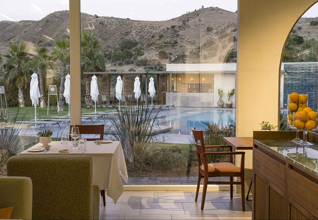 Ristorante con vista piscina e colline, ambiente elegante e accogliente.