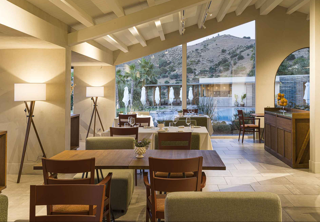 Ristorante elegante con vista sulle colline, arredamento moderno e ampie finestre.