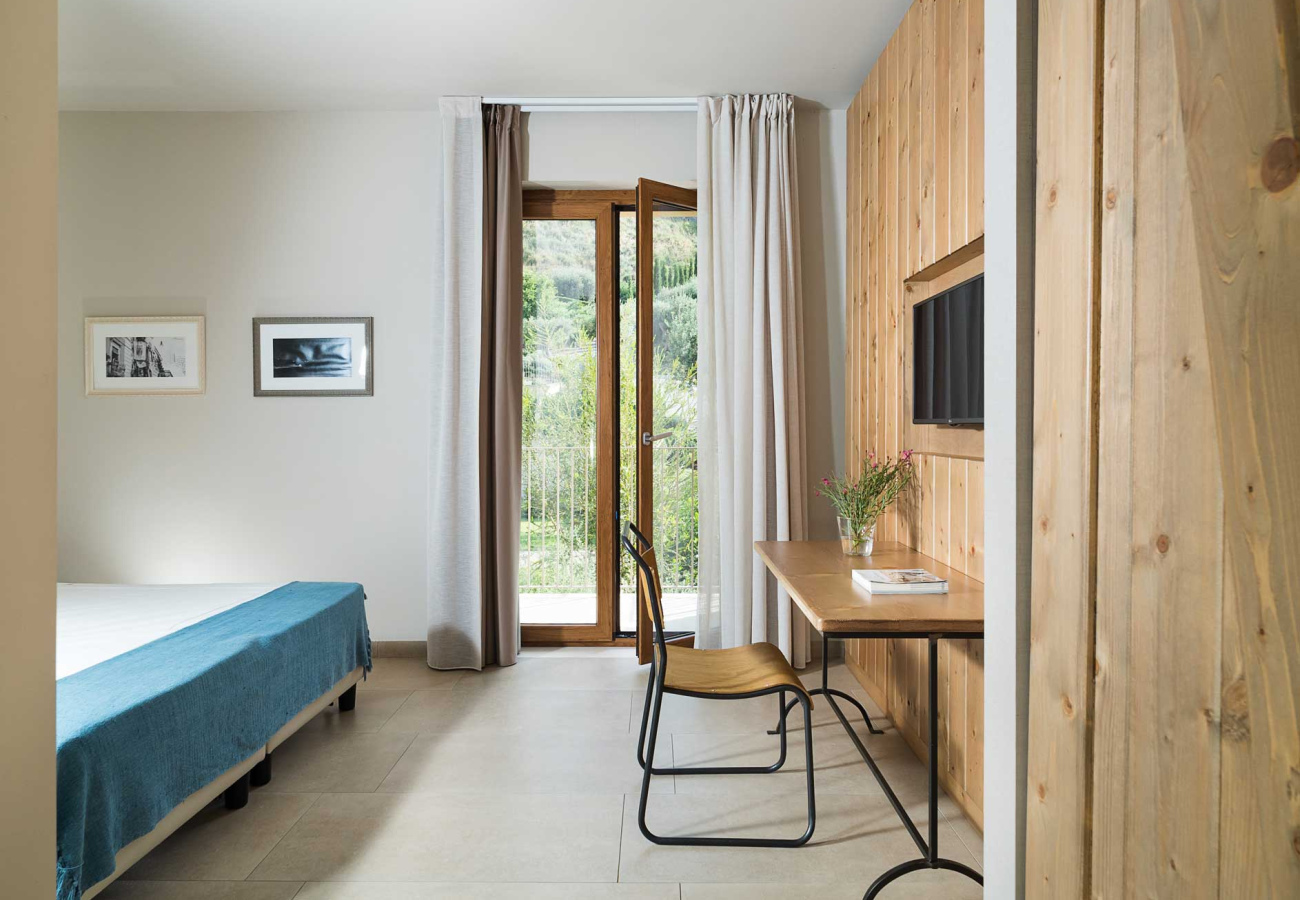 Camera moderna con arredi in legno, balcone e decorazioni minimaliste.